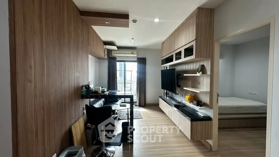 Modern apartment interior with open living room and bedroom, featuring sleek wooden finishes and natural light.