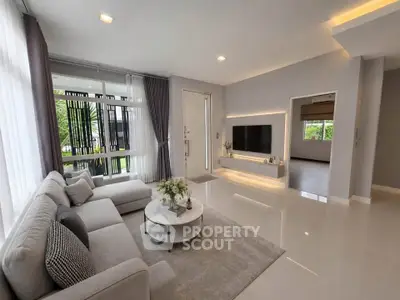 Modern living room with sleek design and large windows offering natural light.