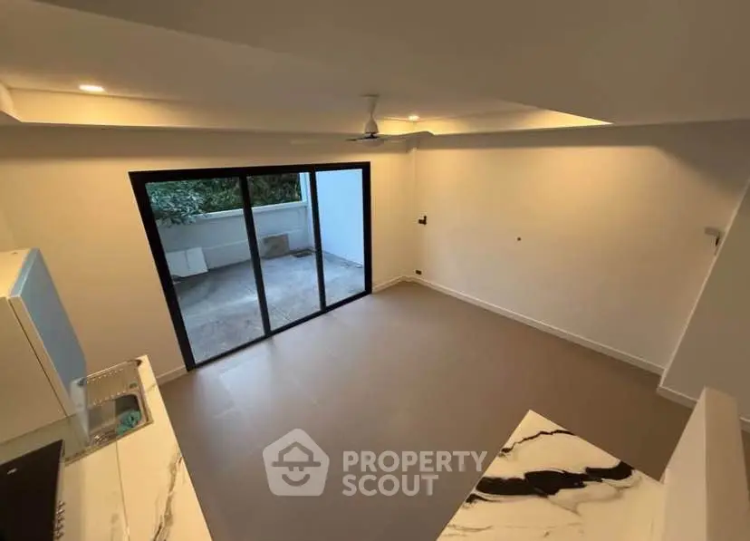 Modern open-plan living room with large sliding doors to balcony
