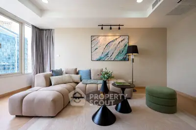 Modern living room with stylish furniture and large windows offering city views.