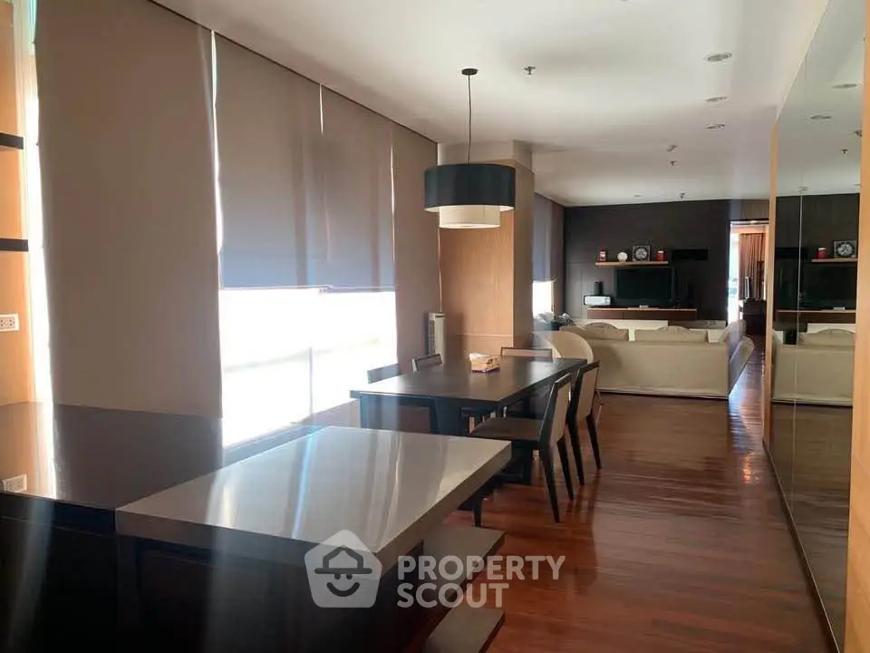Spacious modern living room with elegant dining area and natural light.