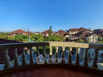 Charming balcony view overlooking suburban rooftops and lush greenery.