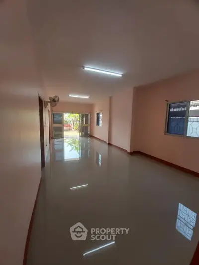 Spacious living room with glossy floors and large windows for natural light.