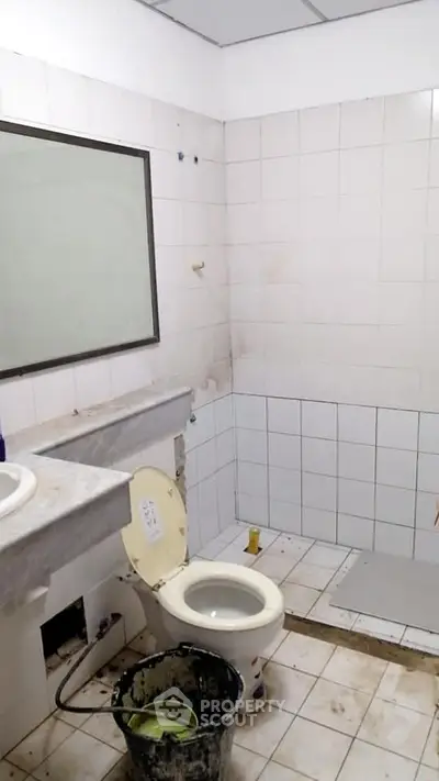 Spacious bathroom with tiled walls and modern fixtures, ideal for renovation projects.