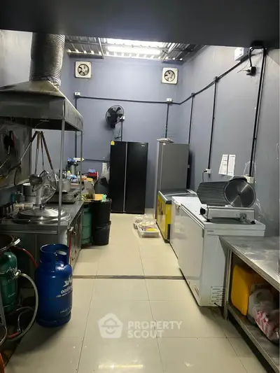 Commercial kitchen with industrial appliances and storage space