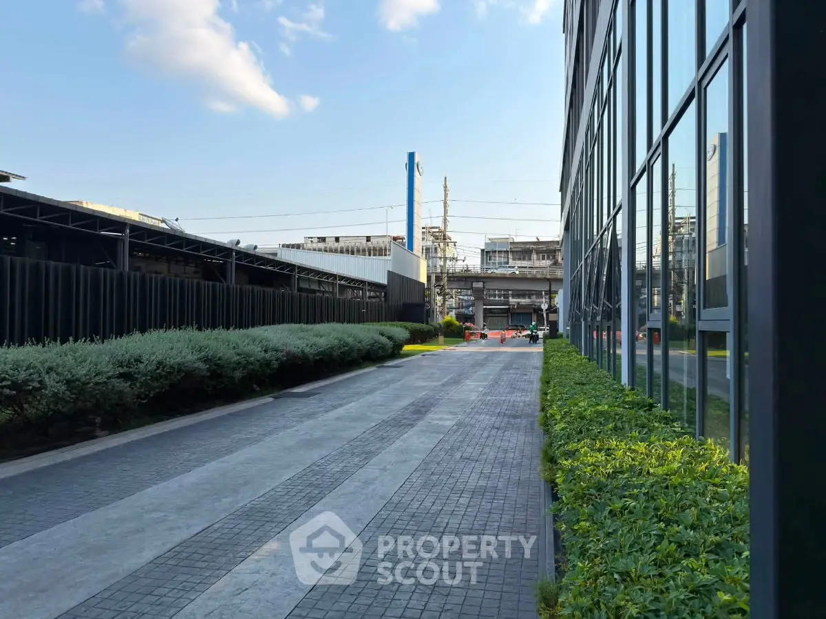 Modern building exterior with sleek glass facade and landscaped walkway.