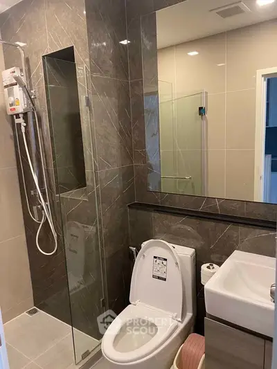 Modern bathroom with glass shower and sleek fixtures in a contemporary home.