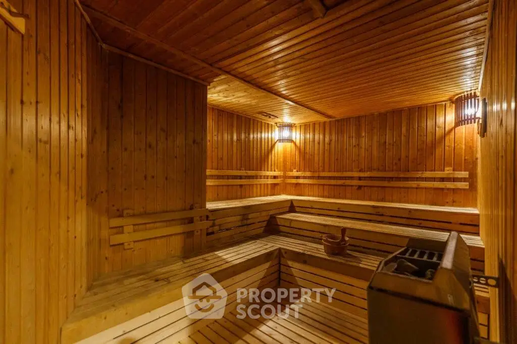 Luxurious wooden sauna room with warm lighting and spacious seating, perfect for relaxation.