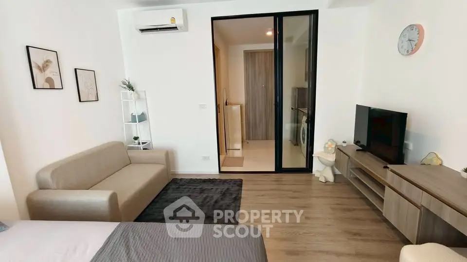 Modern living room with stylish decor and open layout, featuring a cozy sofa and sleek entertainment unit.