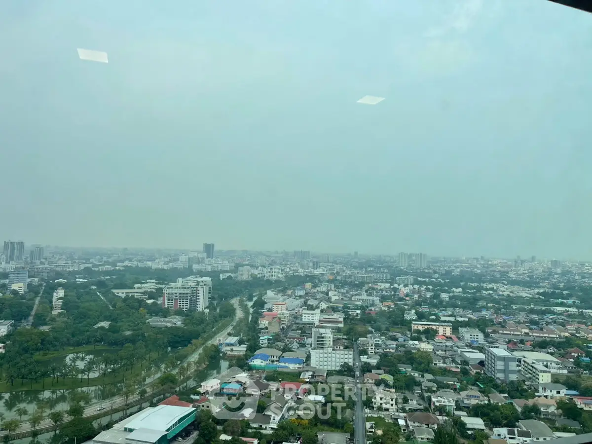 Stunning panoramic cityscape view from high-rise building, showcasing urban landscape and greenery.