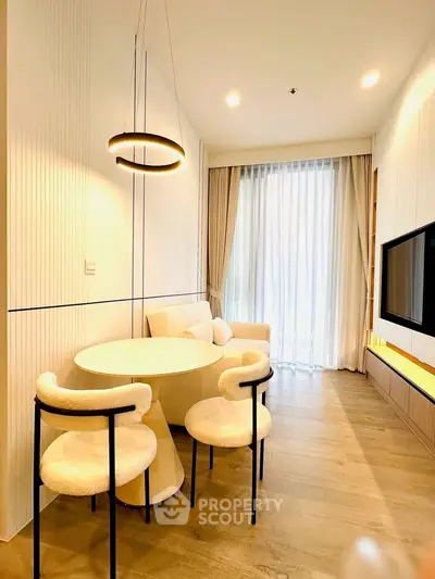 Modern living room with elegant furniture and ambient lighting, featuring a cozy seating area and large window.