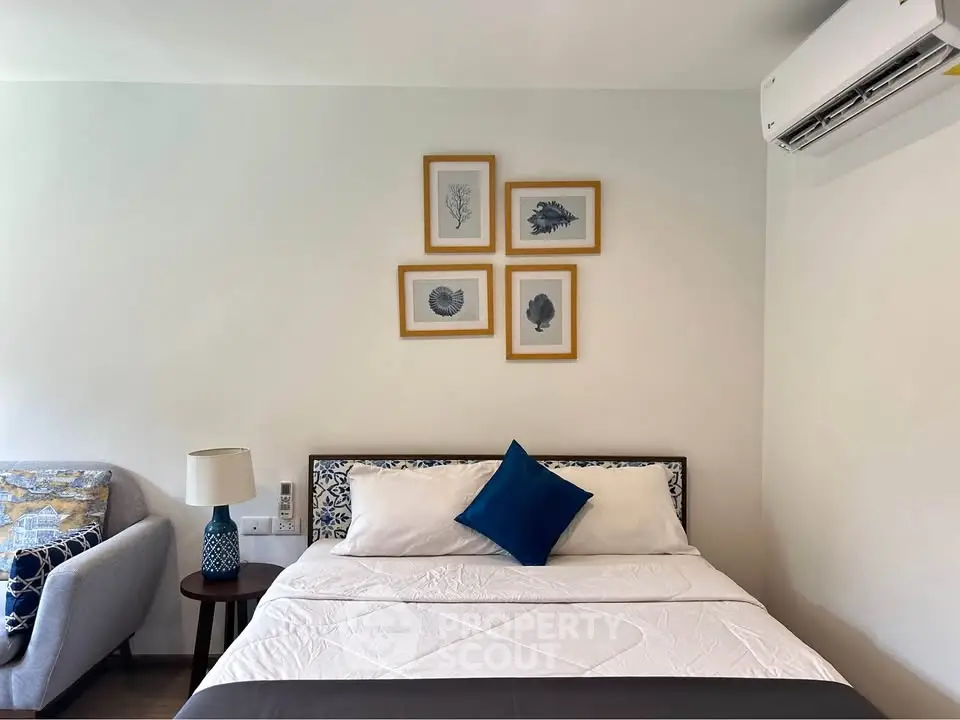 Cozy bedroom with modern decor, featuring a comfortable bed, stylish artwork, and air conditioning.