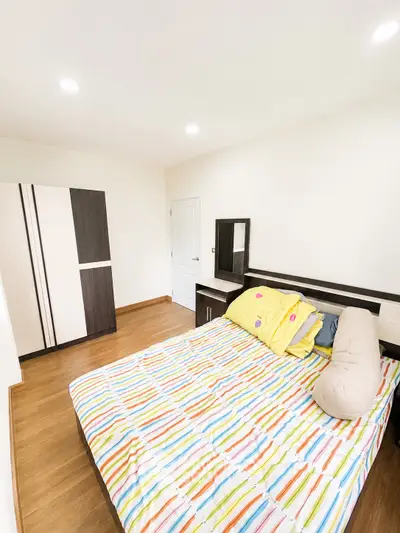 Bright and cozy bedroom with colorful bedding and modern furniture, perfect for relaxation.