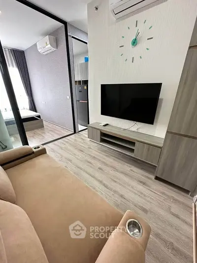 Modern living room with sleek TV setup and stylish furniture in a contemporary apartment.