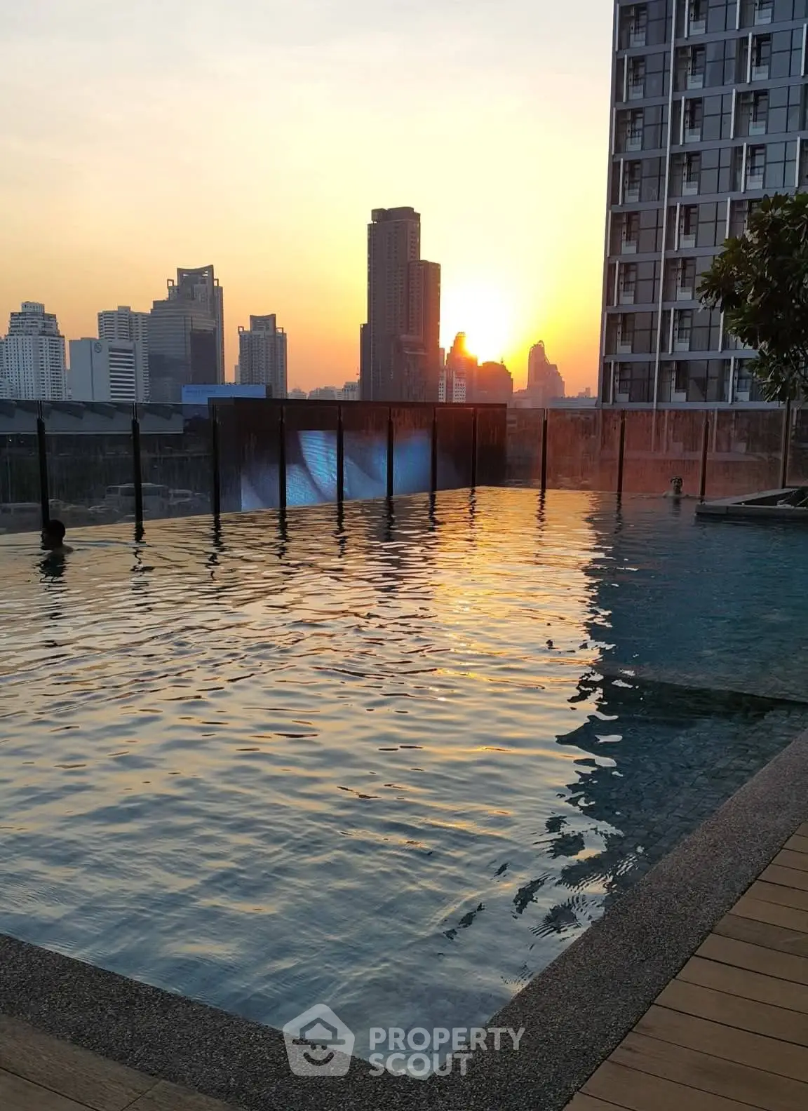 Stunning rooftop pool with city skyline view at sunset, perfect for luxury urban living.