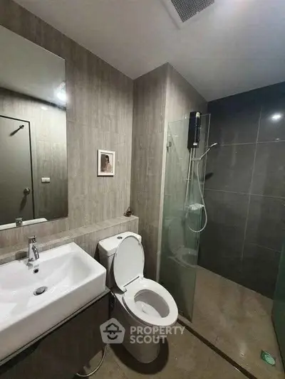 Modern bathroom with sleek design featuring glass shower and stylish sink.