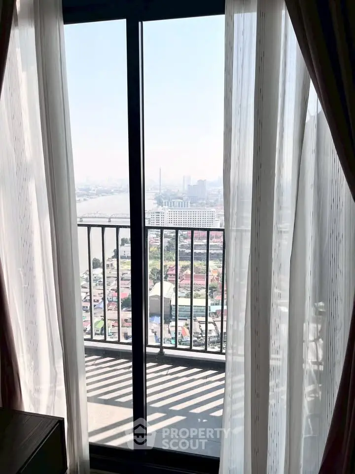Stunning high-rise balcony view with cityscape and river, perfect for urban living.
