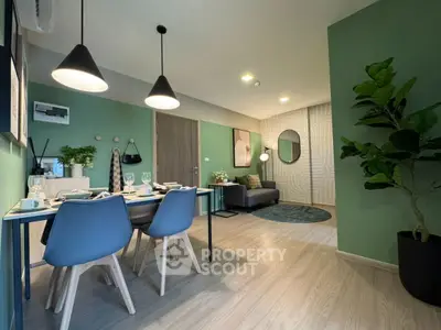 Modern living room with dining area, stylish decor, and green accent walls.