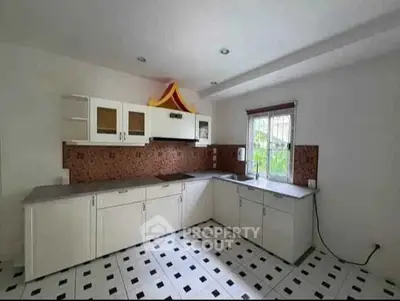 Spacious kitchen with modern cabinetry and ample natural light, perfect for culinary enthusiasts.