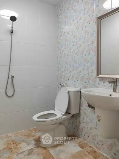 Modern bathroom with floral tiles, shower, and sleek fixtures.