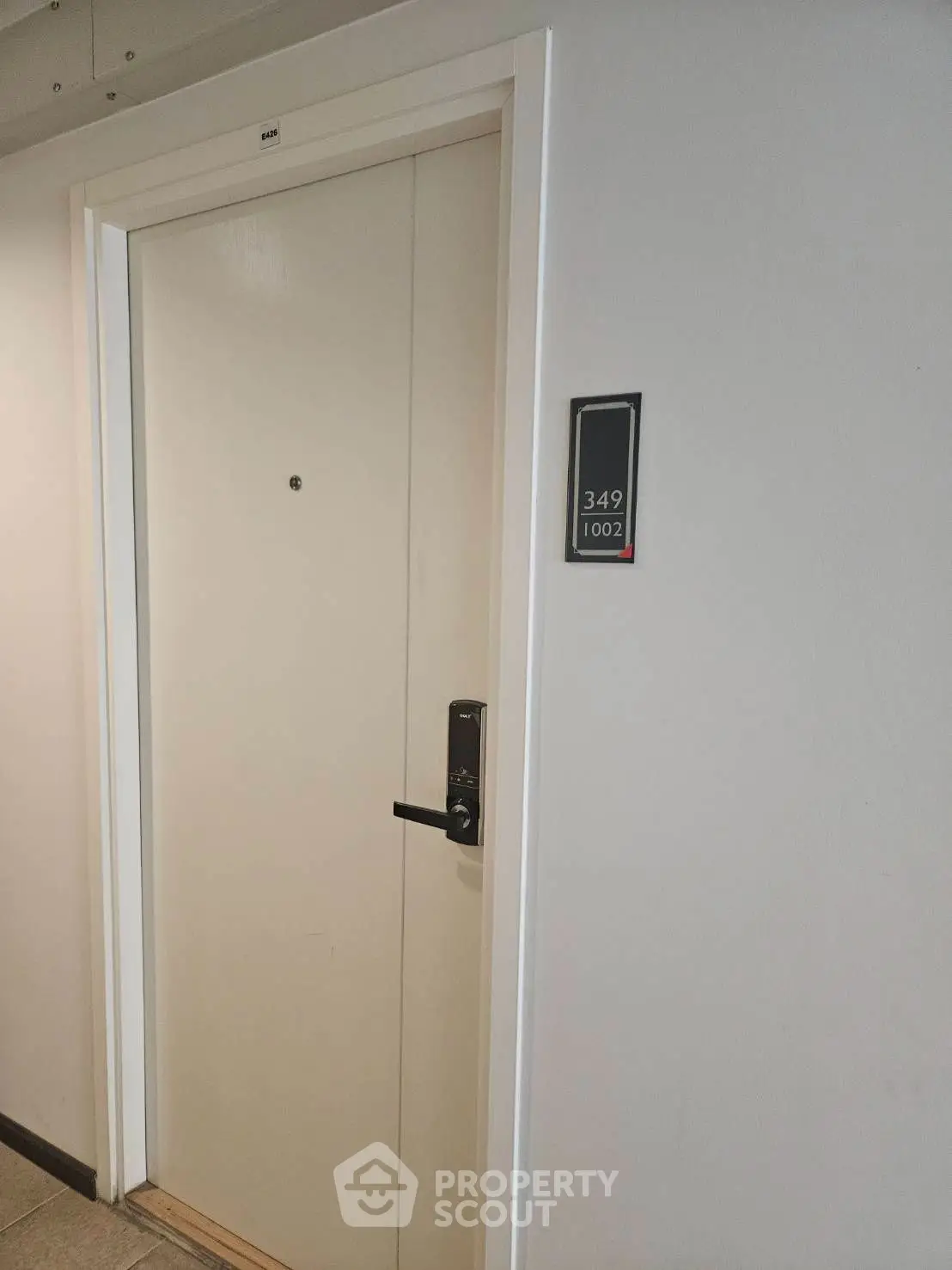Modern apartment entrance with secure door and room number plaque, ideal for urban living.