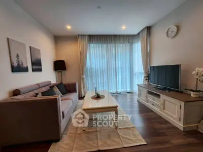 Cozy living room with modern decor and large window for natural light.