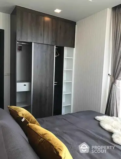 Modern bedroom with stylish wardrobe and cozy bedding in a contemporary apartment.