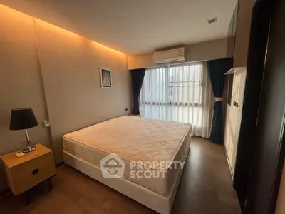 Spacious bedroom with large window and modern decor