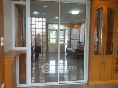 Spacious living room with glass sliding doors and elegant wooden cabinetry.