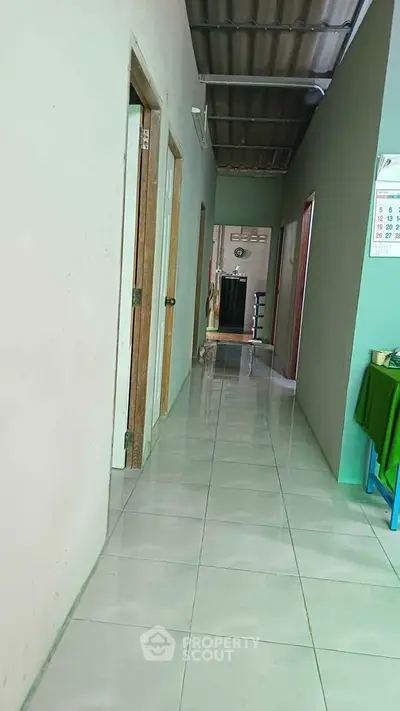 Spacious hallway with tiled flooring and multiple doorways in a residential property.