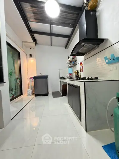 Modern kitchen with sleek design, gas stove, and ample natural light, perfect for culinary enthusiasts.