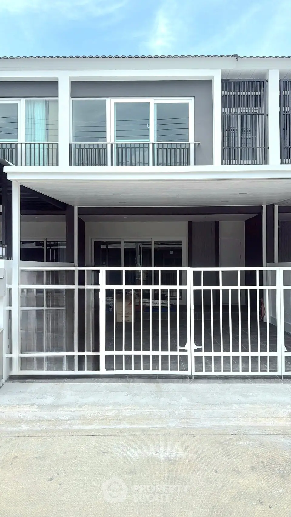 Modern townhouse exterior with sleek design and gated entrance, perfect for urban living.