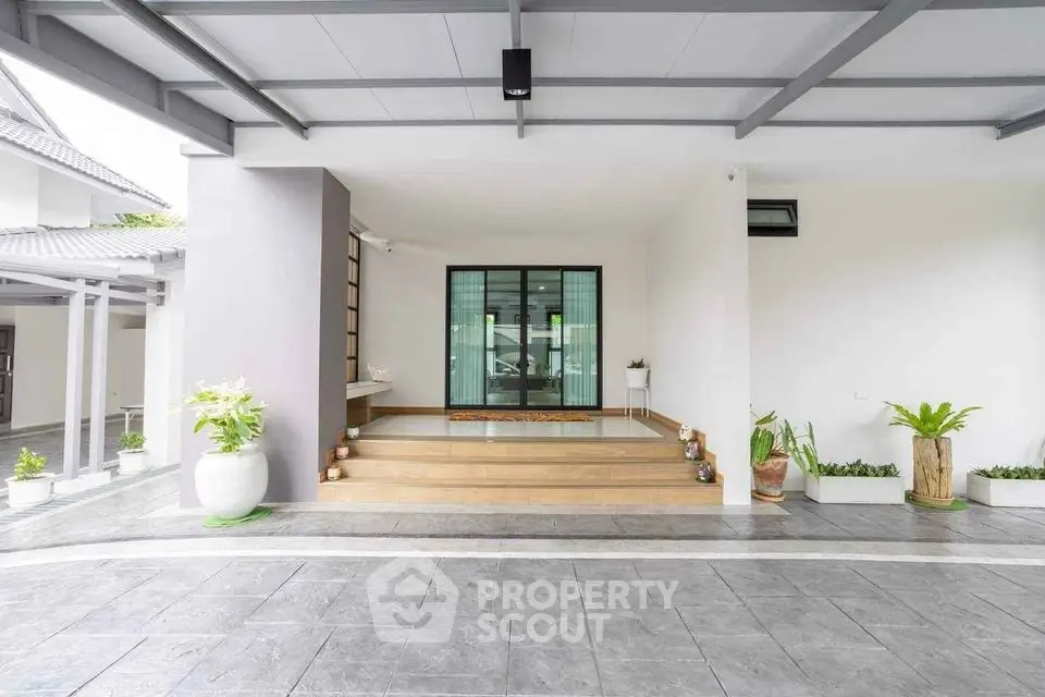Modern home entrance with sleek design and potted plants, showcasing a welcoming ambiance.