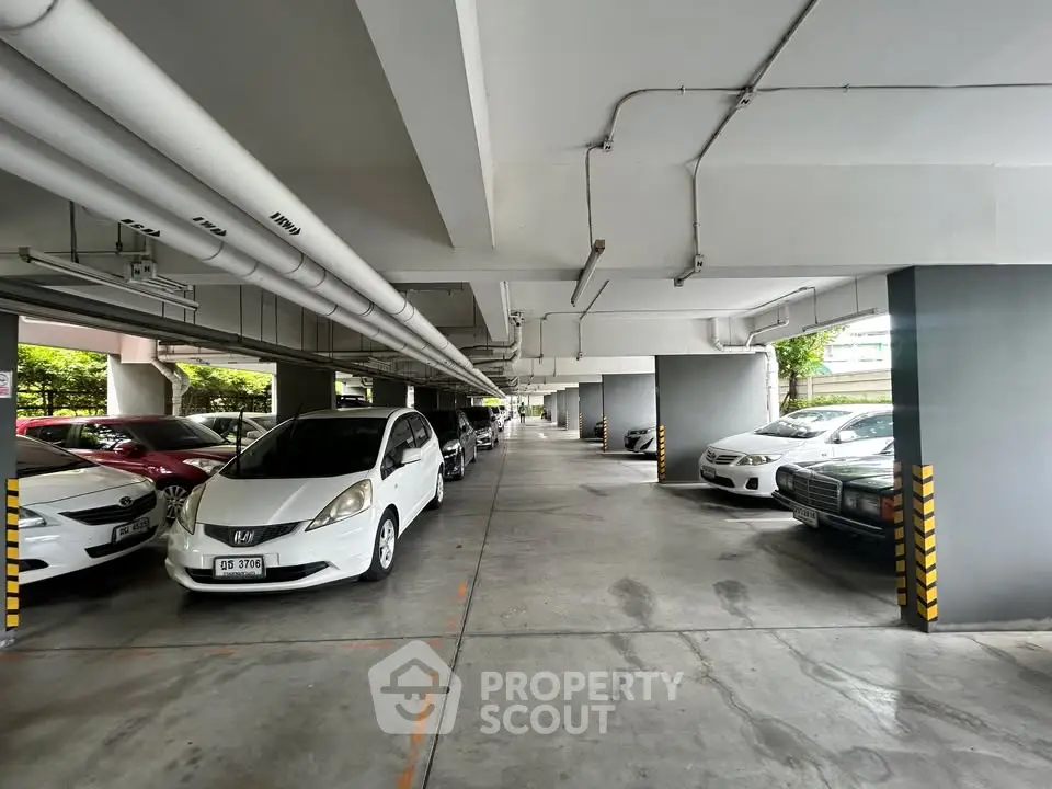 Spacious indoor parking area with multiple cars parked in a modern building.