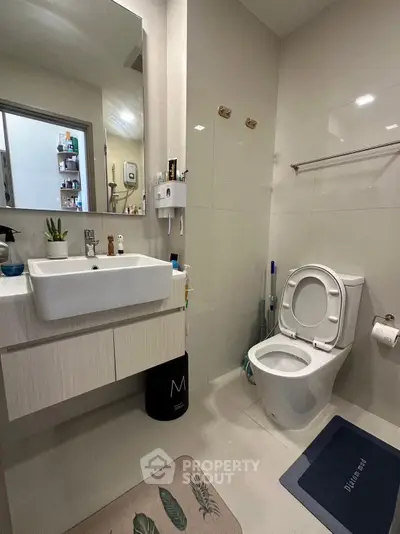 Modern bathroom with sleek fixtures and stylish decor, featuring a floating vanity and contemporary toilet design.
