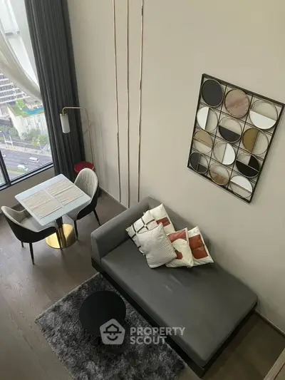Modern living room with stylish decor and city view, featuring a cozy sofa and chic dining area.