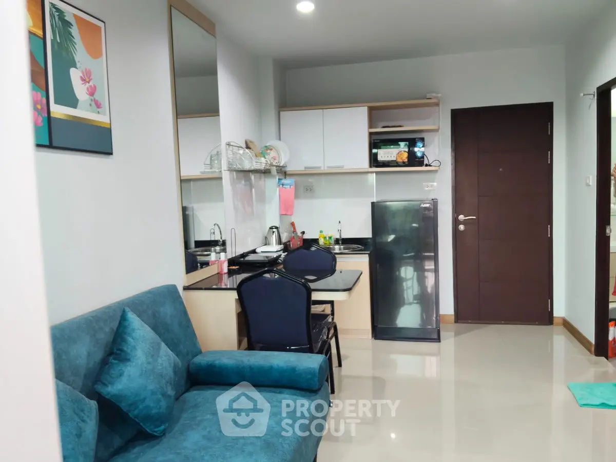 Modern apartment interior with cozy living area and compact kitchen.