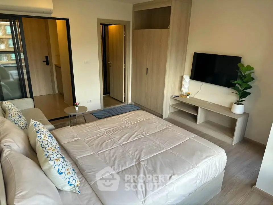 Modern bedroom with stylish decor and wall-mounted TV in a cozy apartment.