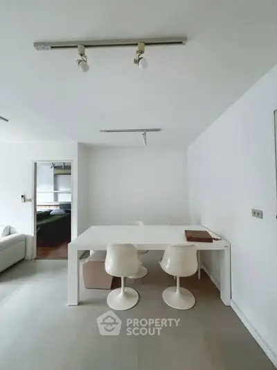 Modern minimalist dining area with white furniture and sleek design