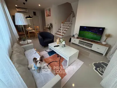 Charming living room with modern decor, cozy seating, and a playful dog, perfect for relaxation and entertainment.