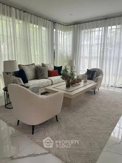 Elegant living room with modern furniture and large windows for natural light.