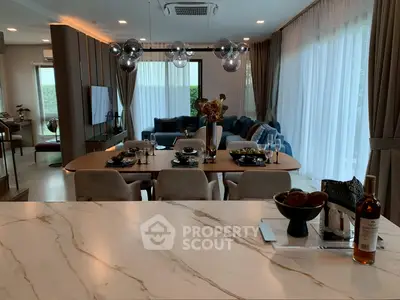 Luxurious open-plan living and dining area with modern decor and elegant lighting.