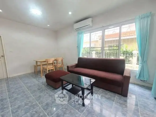 Spacious living room with modern furniture and large window for natural light.