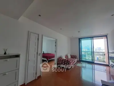 Spacious living room with city view and balcony access in modern apartment.