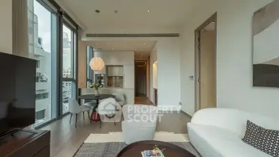 Modern living room with open kitchen in luxury apartment, featuring stylish furniture and large windows.