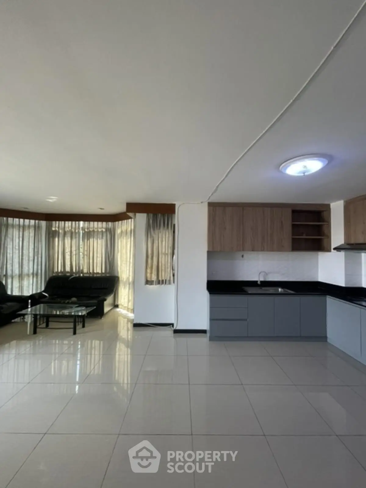 Spacious open-plan living room with modern kitchen and large windows