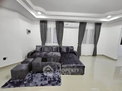 Modern living room with plush gray sofa and elegant curtains