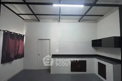 Spacious minimalist kitchen with sleek black countertops and modern cabinetry.