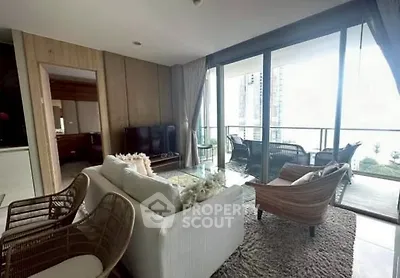 Spacious living room with modern furniture and large balcony offering city views.