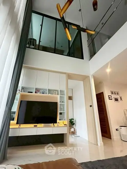 Modern living room with high ceiling and stylish decor in a contemporary home.